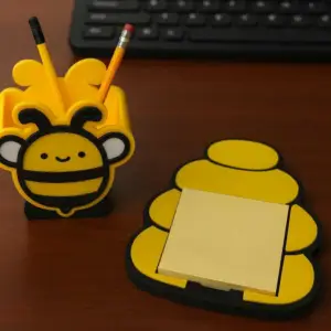 Bee-shaped pen holder with honeycomb notepad tray, 3D printed desk organizer.