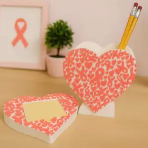 Heart-shaped pen holder with pink ribbon accents and matching notepad tray.