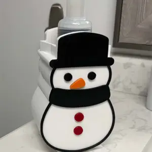 Bring holiday magic to every hand wash. This adorable Snowman Soap Dispenser Holder is the perfect way to dress up your bathroom or kitchen for winter. Crafted with smooth 3D-printed detail, this cheerful snowman securely holds most standard soap bottles — especially the popular Bath & Body Works foaming soap bottles. Whether you’re decorating your home for Christmas, looking for a unique handmade gift, or adding a seasonal touch to your guest bathroom, this snowman makes it fun and festive. Features • ❄️ Fits Bath & Body Works–style foaming soap bottles • ⛄ Cute snowman design that adds instant holiday charm • 🧼 Stable, wobble-free base for sinks, bathrooms, kitchens & office spaces • 🎁 Perfect holiday gift for family, coworkers, and teachers • 🖨️ 3D printed using durable, lightweight material Ideal For • Christmas / winter home décor • Kids’ bathrooms • Office holiday decorations • Hostess gifts • Stocking stuffers Dimensions Designed to fit standard soap dispenser bottles