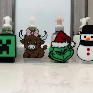 Customizable 3D-printed soap dispenser holder with swappable themed faceplates, designed to fit Bath & Body Works foaming and gel bottles.